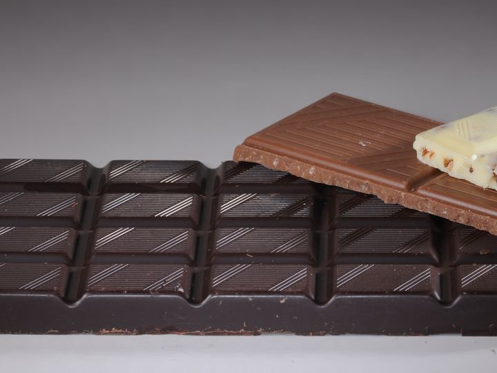 Bars of dark, milk and white chocolate stacked side by side